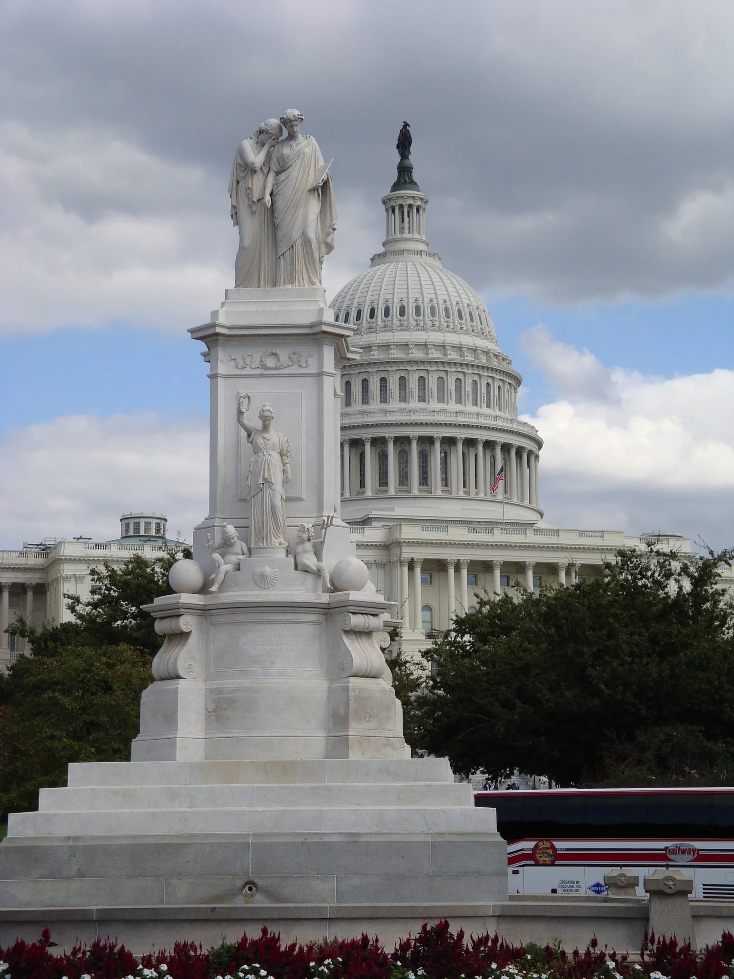 Statue of Grief (also known as America) weeping on the shoulder of History with the US Capitol dome in the background.