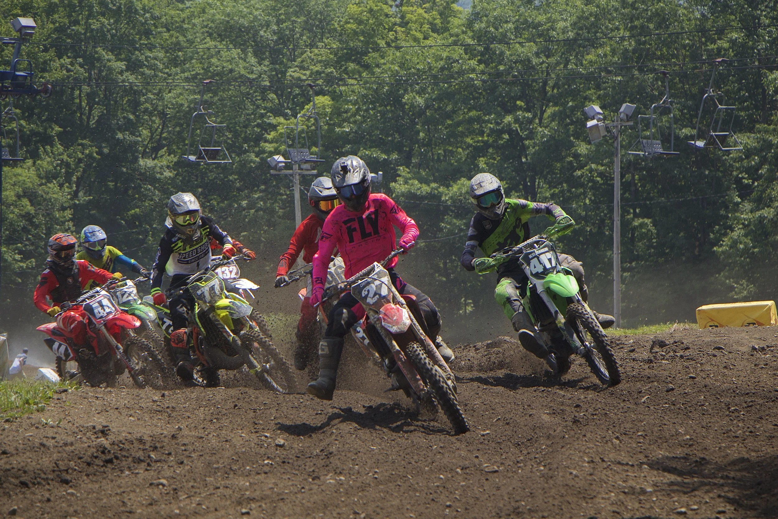 Erin Demers (27), Cody Kramer (417), Skyler Shute (96) and the rest of the Novice class blow by up the hill in to the first corner. Photo credit to Richard Conger ~ CD Films and Photography