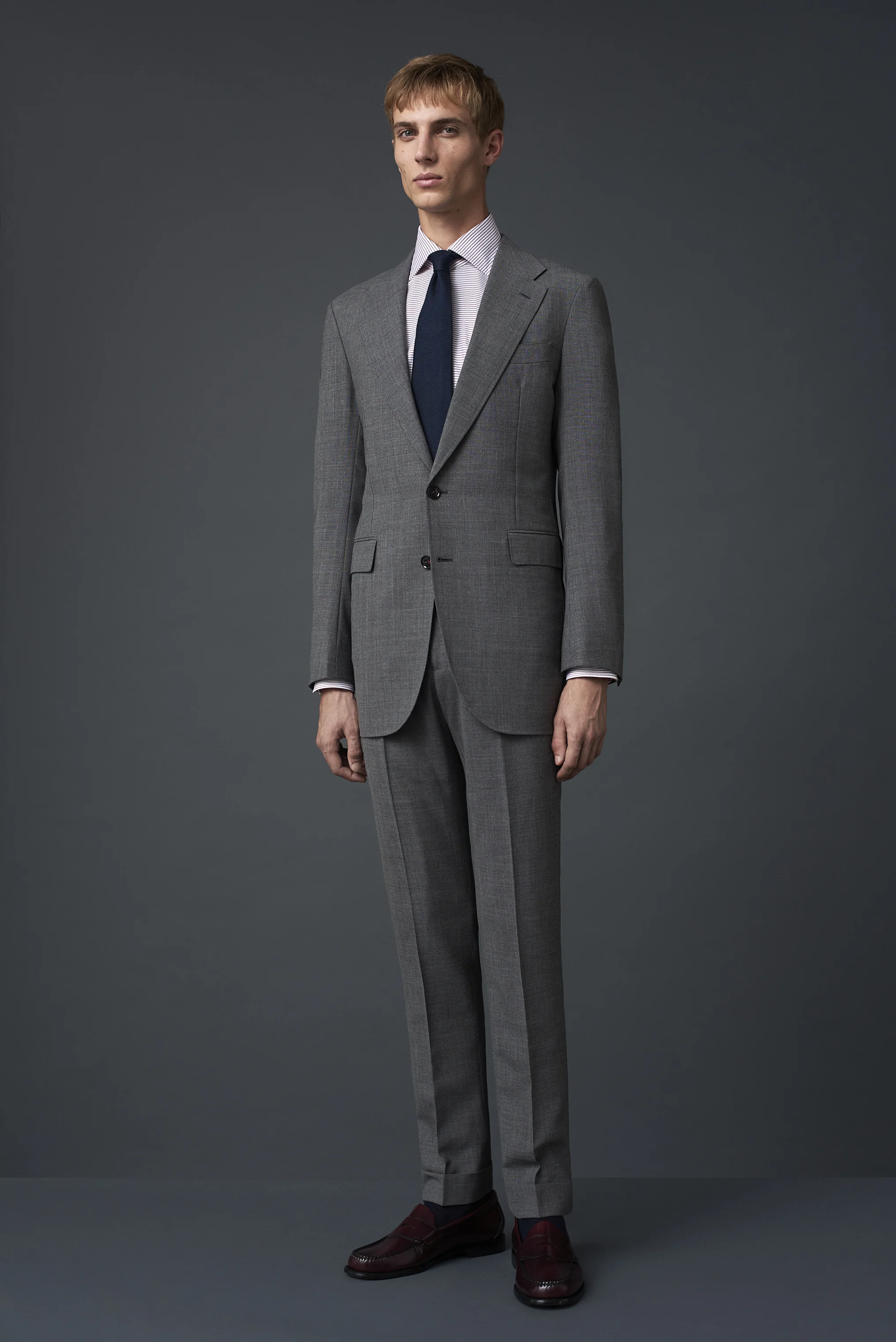 Mid grey fresco three ply suit with a wide notch lapel, woven in Huddersfield. Worn with a horizontal burgundy striped shirt and a French navy grenadine tie made in Como, Italy.