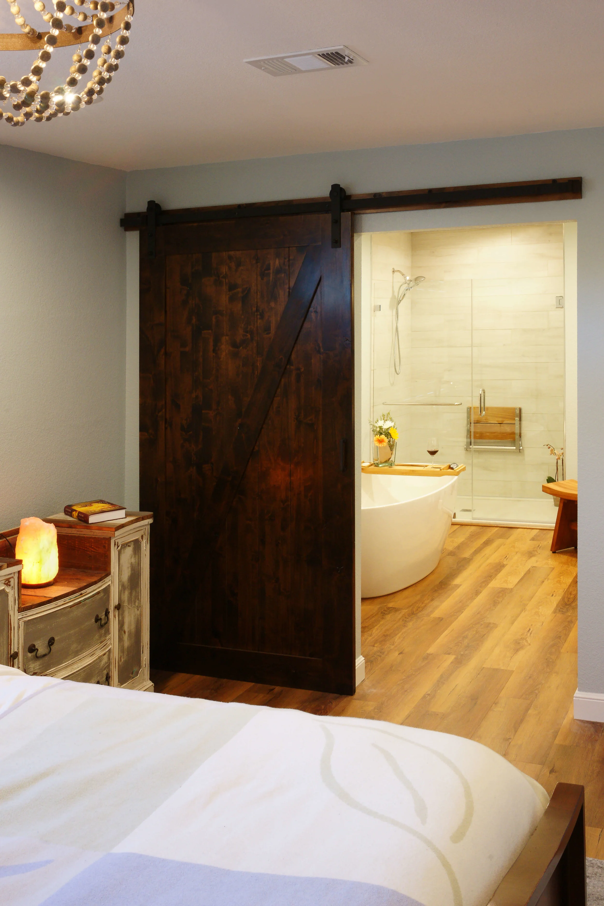 Design detail: Sliding barn door continues the reclaimed feel and maximizes space