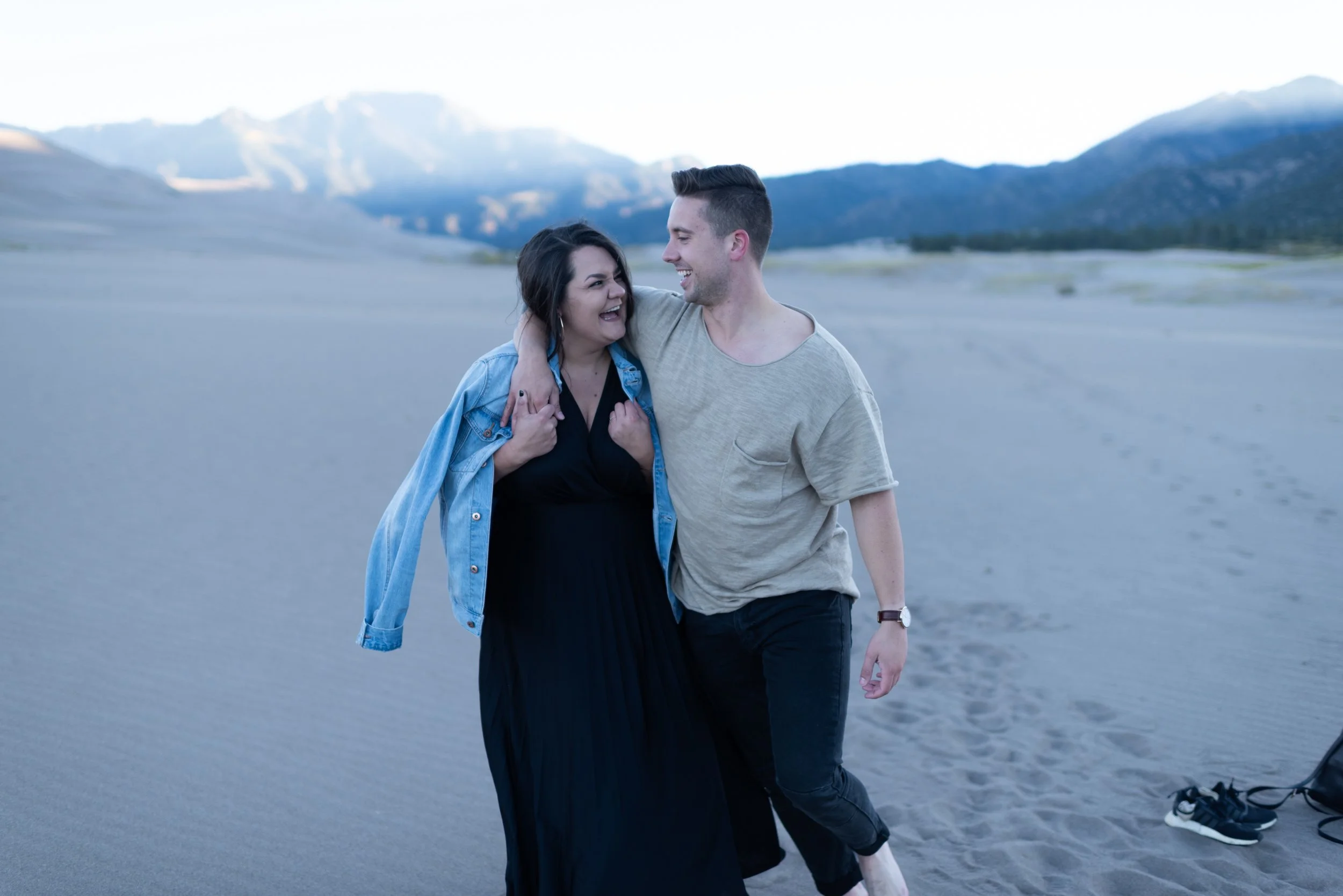 Man with arm around a womans shoulder and walking through a sandy landscape edited with Archipelago Lightroom Presets