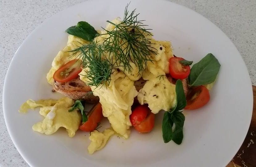 A Fluffy scramble egg with lemon zest and olive oil served on a multigrain sourdough