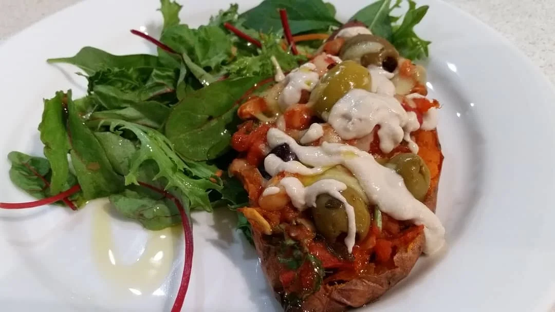Sweet Potato boats with butter beans, olives and seeds and drizzled with a tahini dressing
