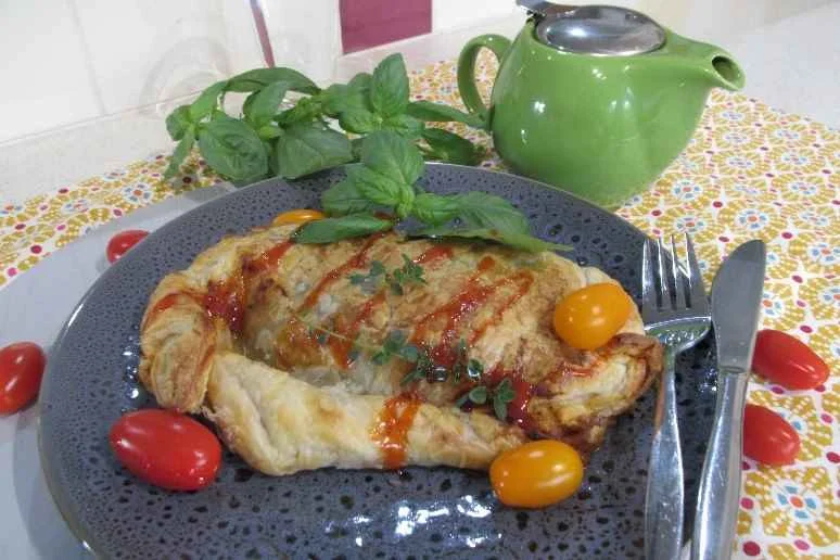 A golden mushroom and spinach calzone with mozzarella cheese. 