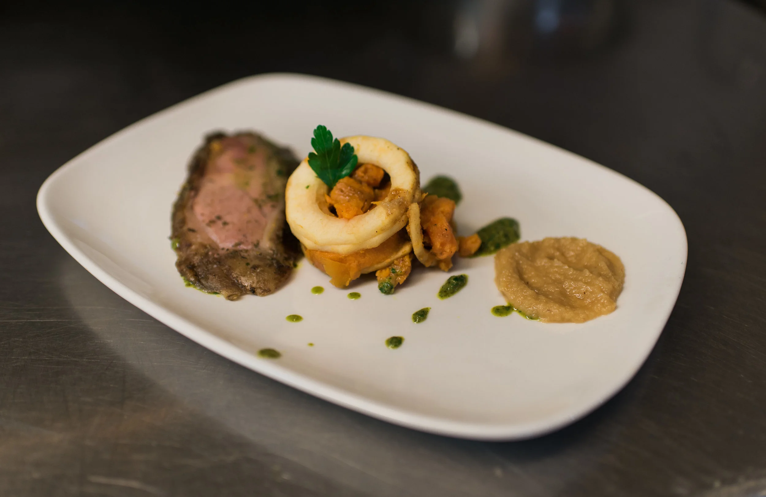Smoked leg of lamb with mint chimichurri over mirliton puree and scalloped sweet potatoes.
