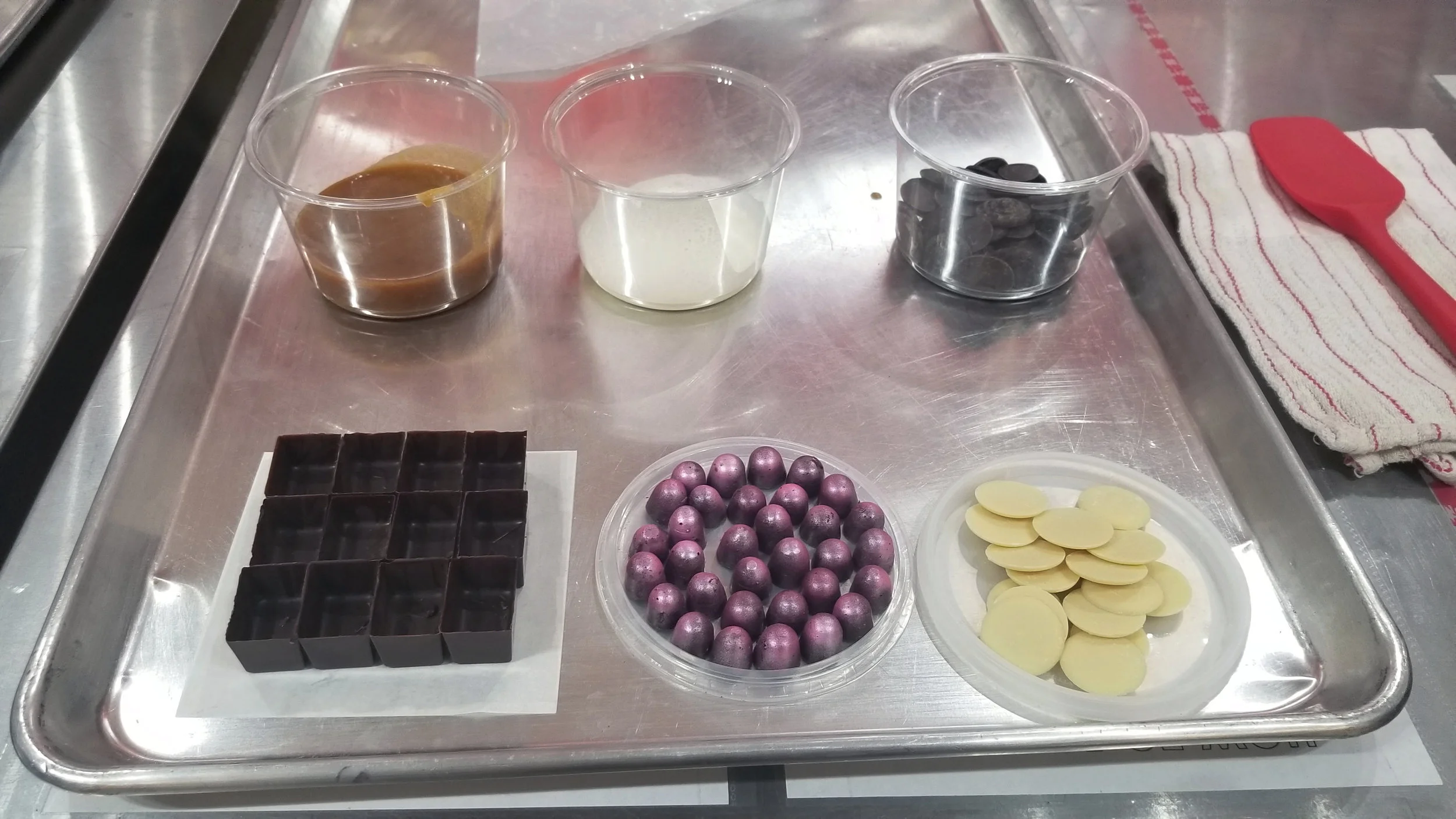 The set up (top row) left: champagne caramel center: cream right: dark chocolate pieces (second row) left: chocolate shells center: chocolate "bubble" filled with sparkle right: white chocolate pieces