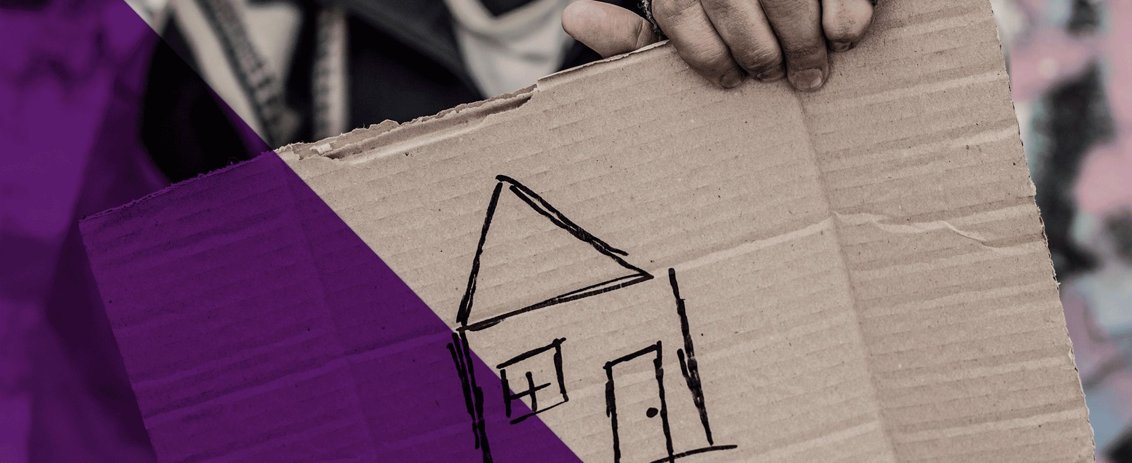 person holding a cardboard with a drawing of a house