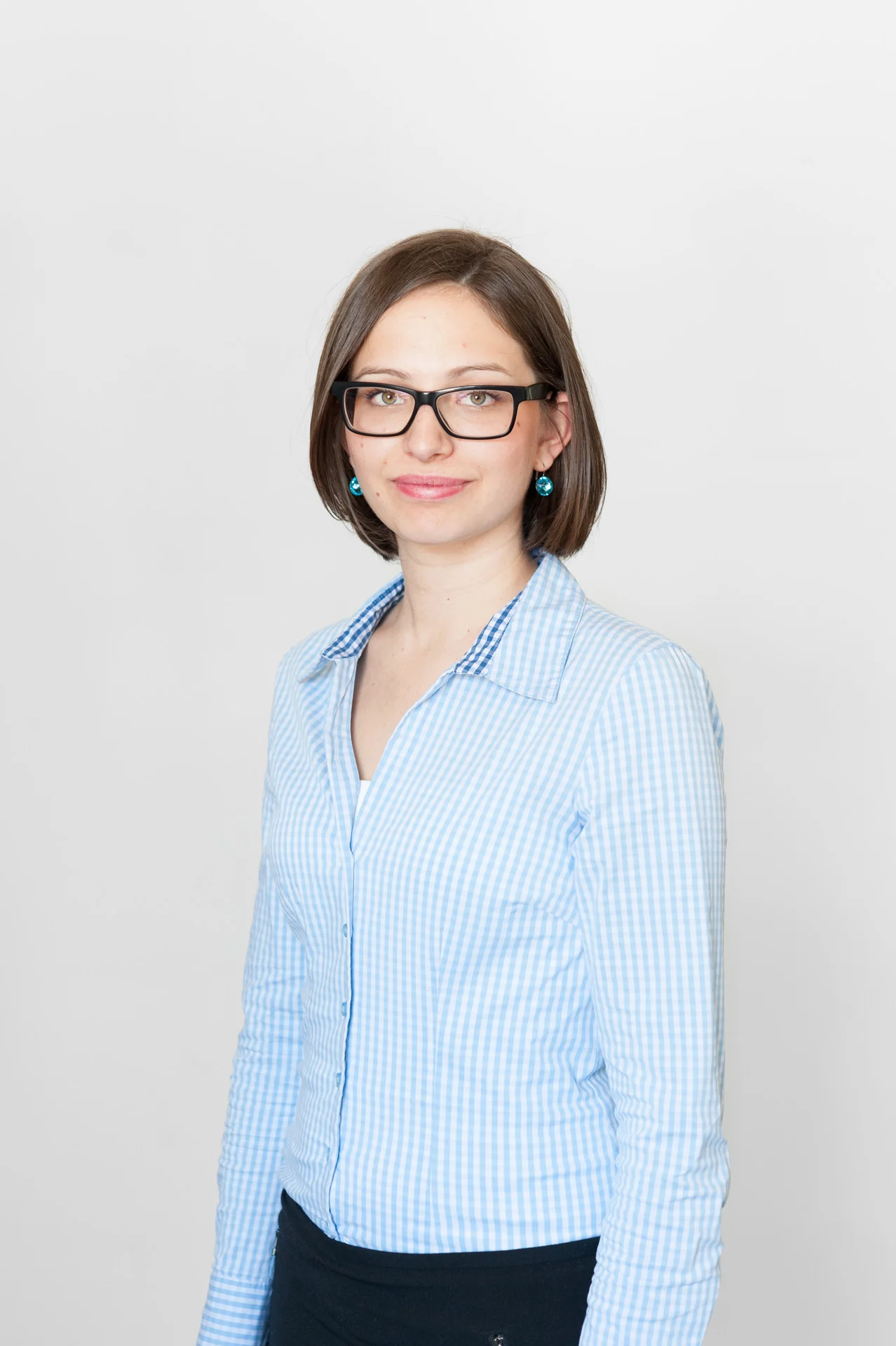 Studioaufnahme: Junge Frau, Blaue Bluse, Brille, Ohrstecker, Weißer Hintergrund