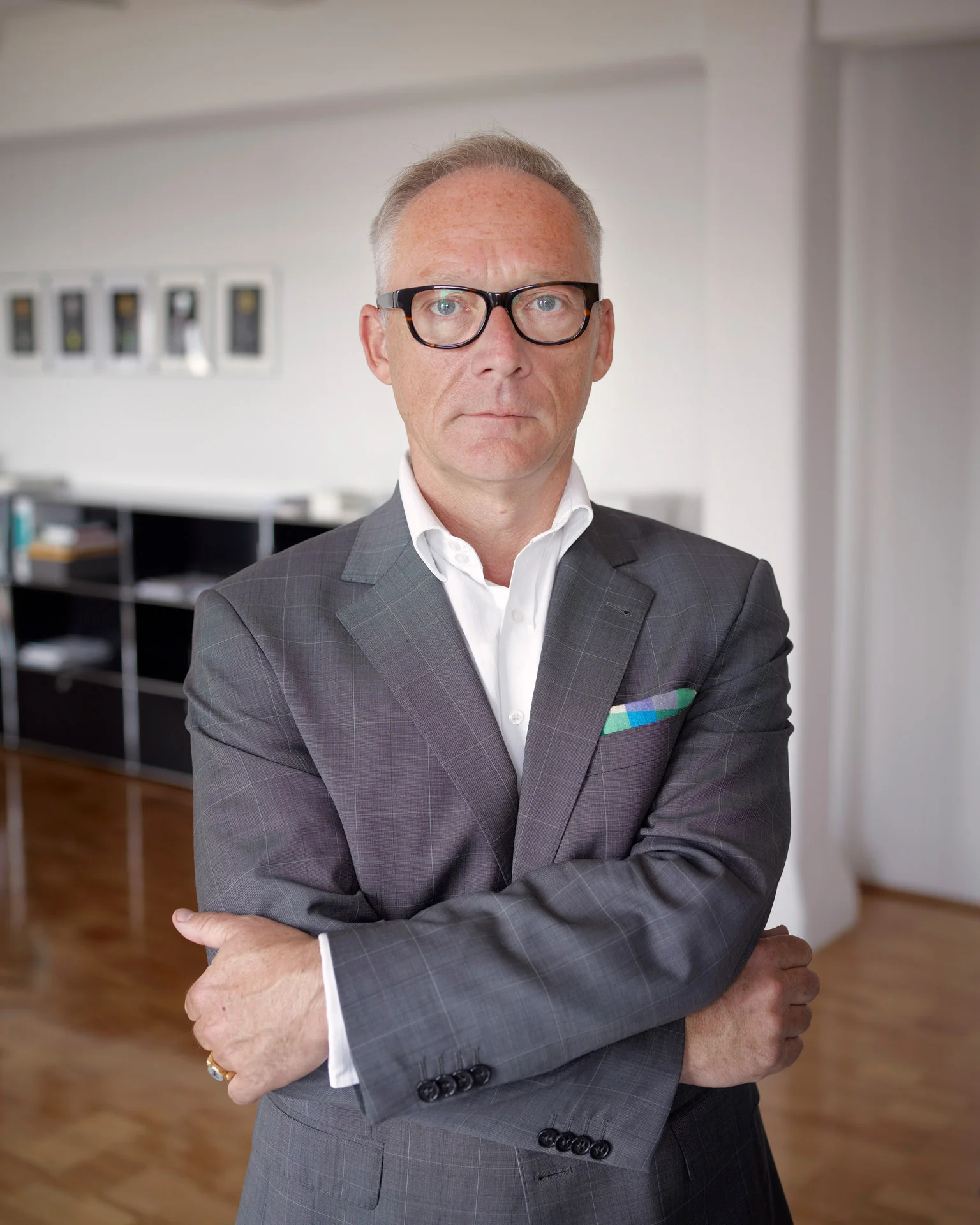 Geschäftsführerporträt: Hochschulrektor mit Brille und verschränkten Armen in Büro