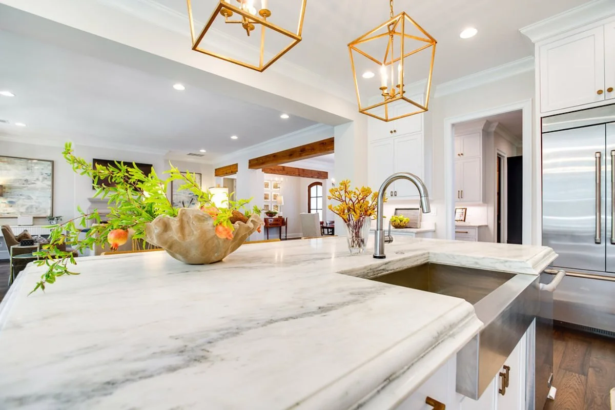 Open kitchen with white island cabinetry connected to a family room in a Tuscaloosa home.
