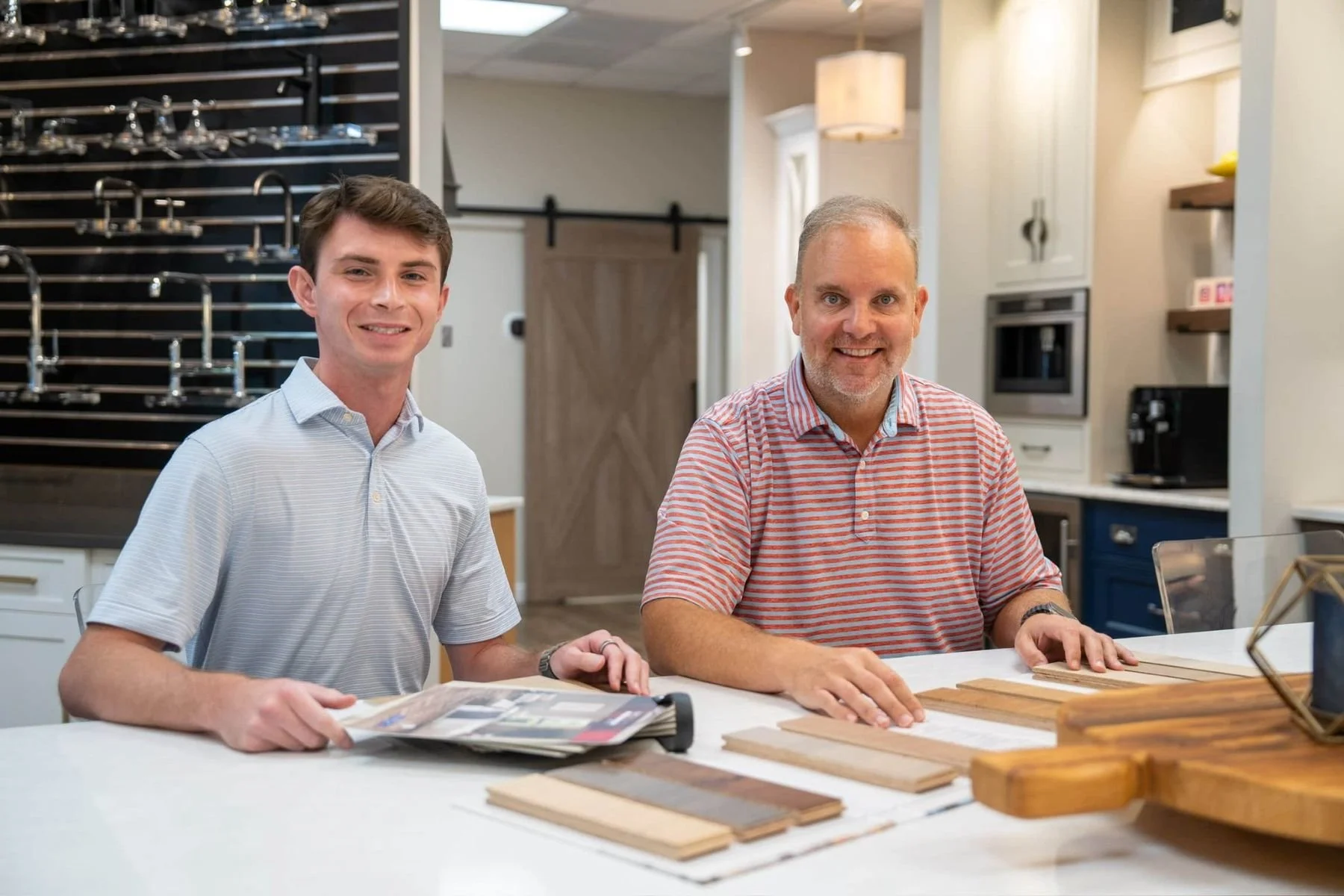 Toulmin Kitchen & Bath team reviewing wood flooring samples during a kitchen design consultation in Tuscaloosa.