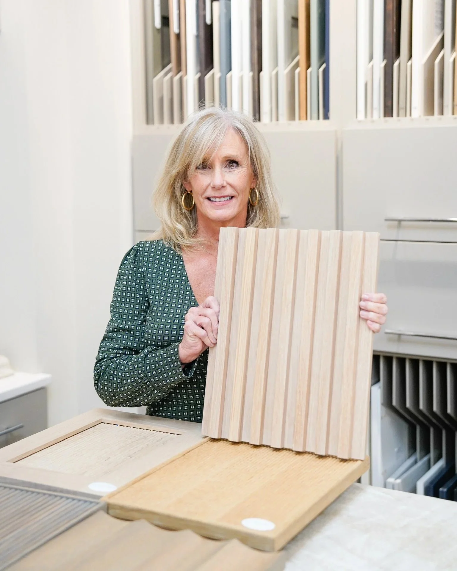 A kitchen designer shows off a fluted cabinet door in the Toulmin Kitchen & Bathroom Tuscaloosa showroom.