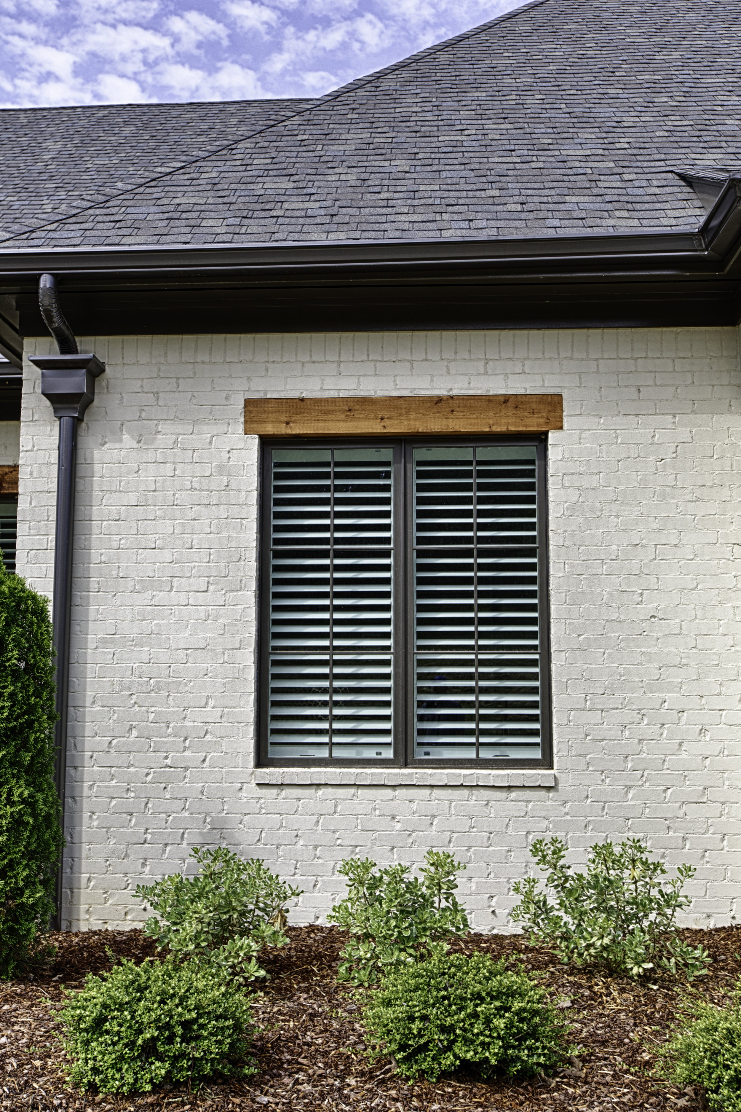 Black replacement windows on a white-washed brick home in Alabama