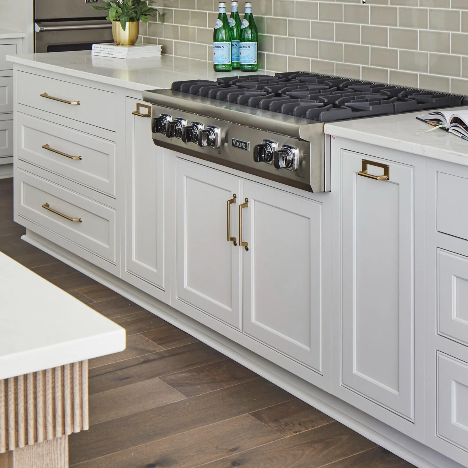 Inset Cabinetry with Brass Hardware and Integrated Range