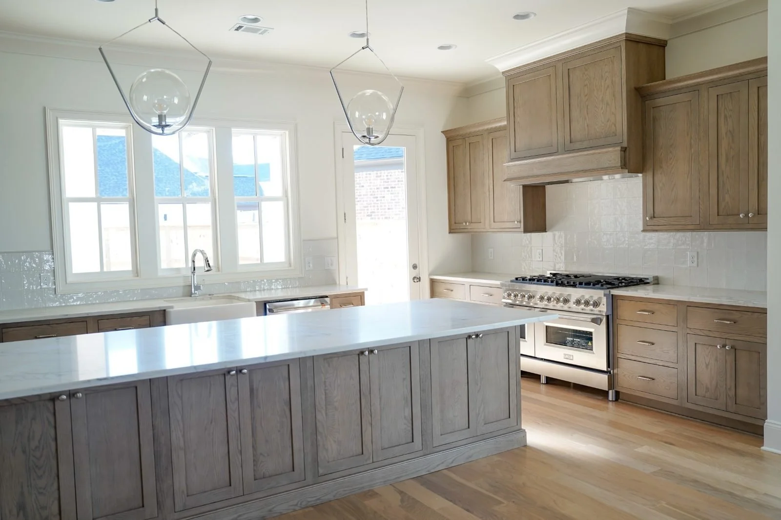 This kitchen showcases custom cabinets that exude warmth and character. The white oak cabinetry with inset detailing, adds a refined, timeless aesthetic while allowing the natural beauty of the wood grain to shine through.