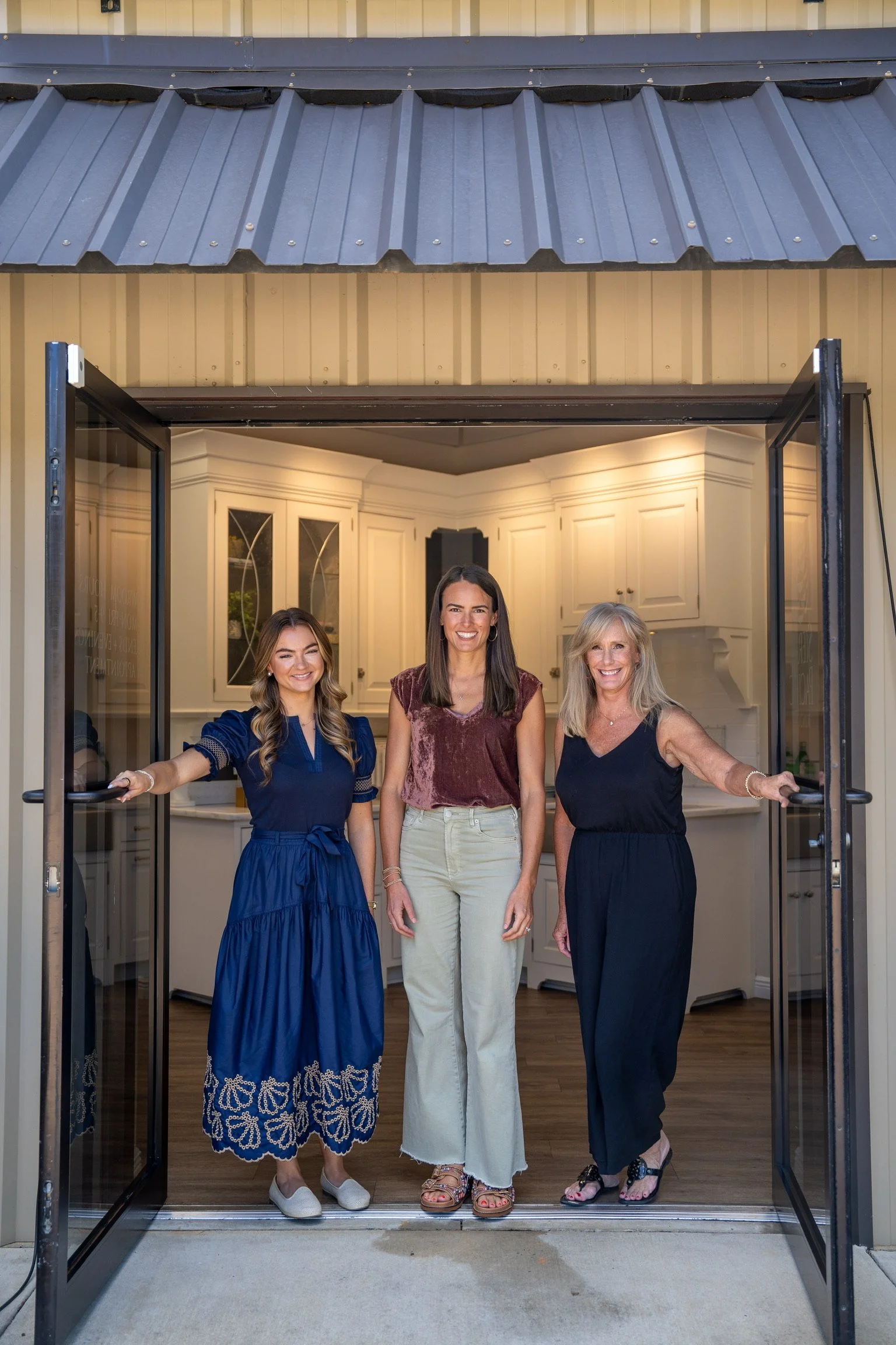 three interior designers standing in the doorway of the Toulmin Kitchen & Bath Design studio