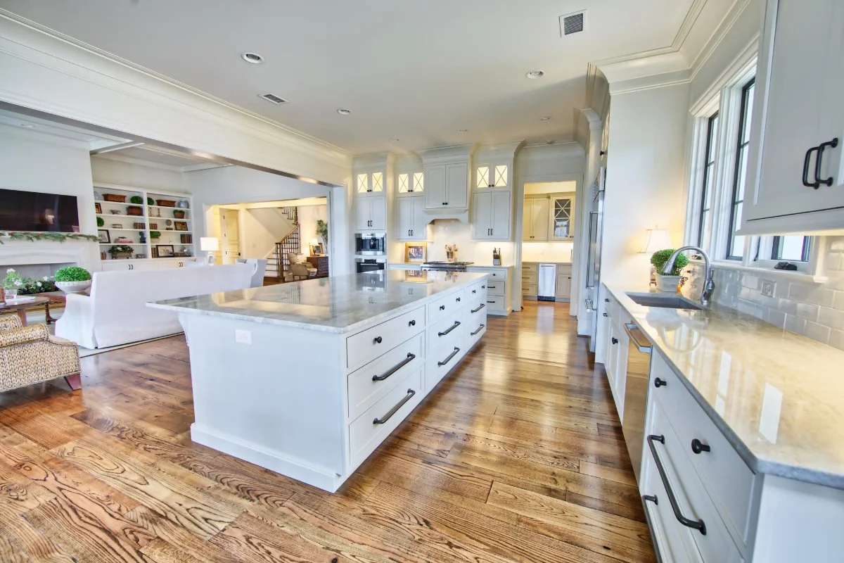 Open kitchen layout with white cabinets, granite countertops, and a spacious island in Tuscaloosa.