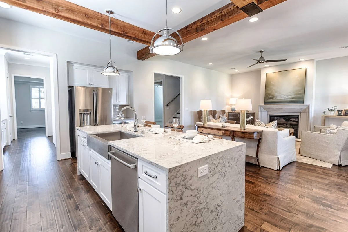 Bright remodeled Tuscaloosa kitchen with a large island, white cabinetry, and pendant lighting.