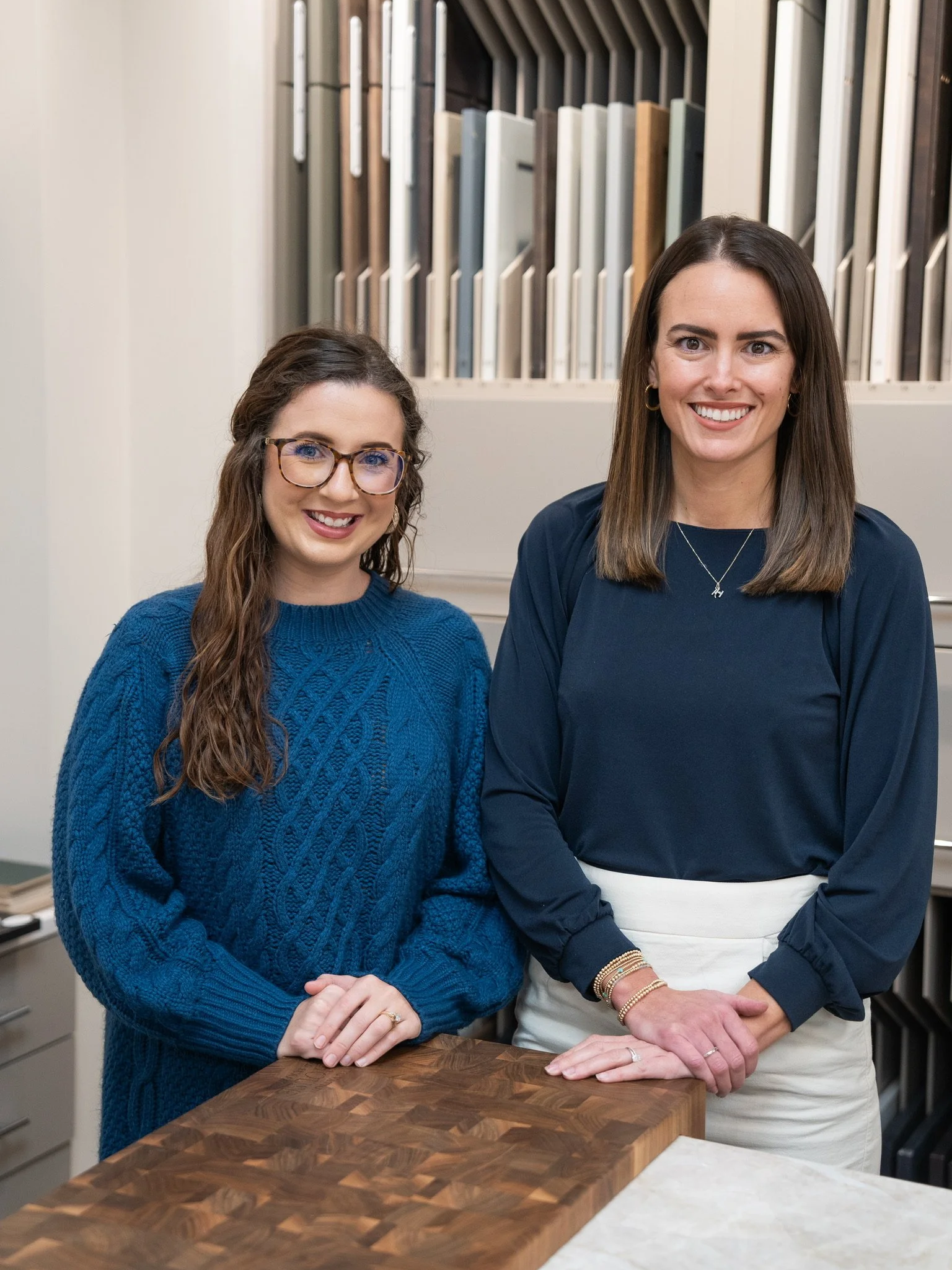 Members of the Toulmin Kitchen & Bath design team stand in the Tuscaloosa showroom surrounded by cabinetry finish samples and custom design selections for luxury kitchen and bathroom projects.