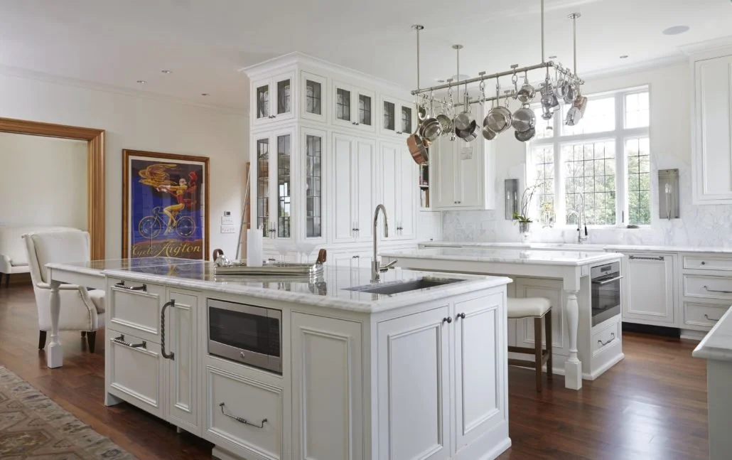 White kitchen with two custom islands for food prep, storage, appliances and seating