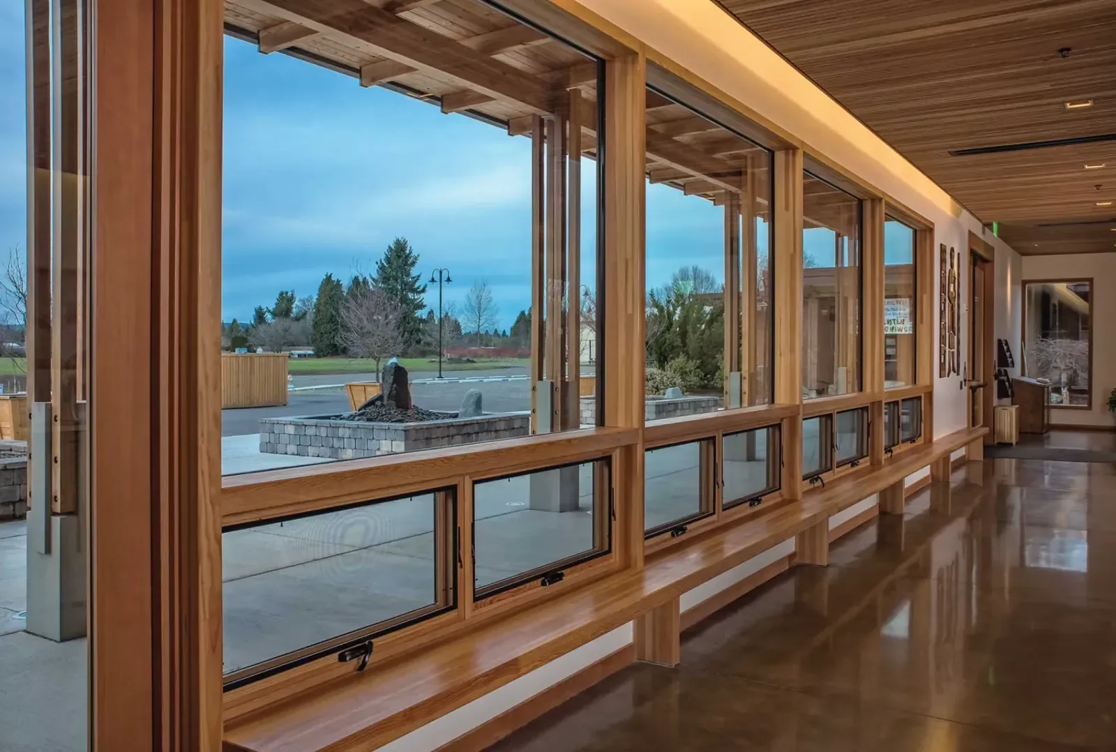 Large timber curtain wall window system featuring floor-to-ceiling glass and wood framing, maximizing natural light and outdoor views.