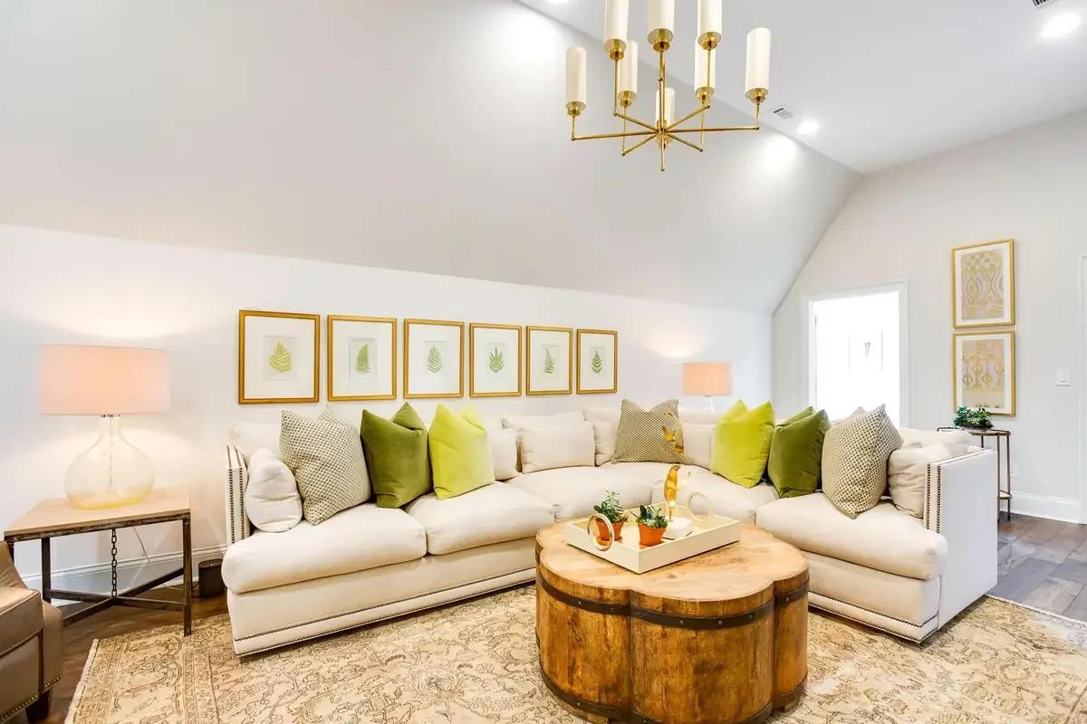 Bright family room in a custom Tuscaloosa home featuring comfortable seating, vaulted ceilings, designer lighting, and timeless interior design.