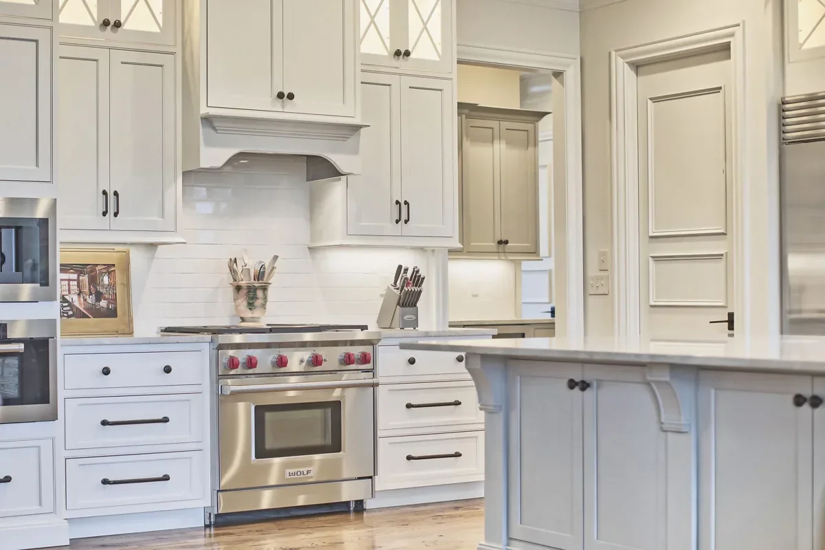 Custom kitchen remodel in Tuscaloosa, Alabama featuring gray cabinetry, quartz countertops, and modern pendant lighting.