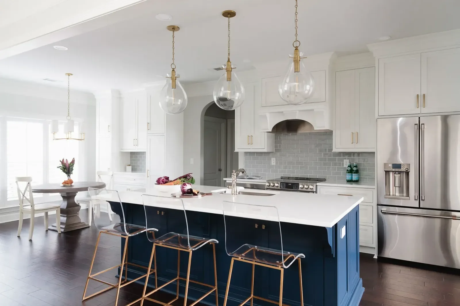 Classic blue kitchen remodel in Tuscaloosa featuring custom white cabinetry, a navy blue island, quartz countertops, and modern pendant lighting by Toulmin Kitchen & Bath.
