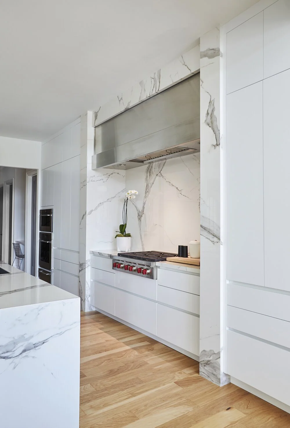Modern Kitchen with White Slab Cabinets and Marble Accent Wall