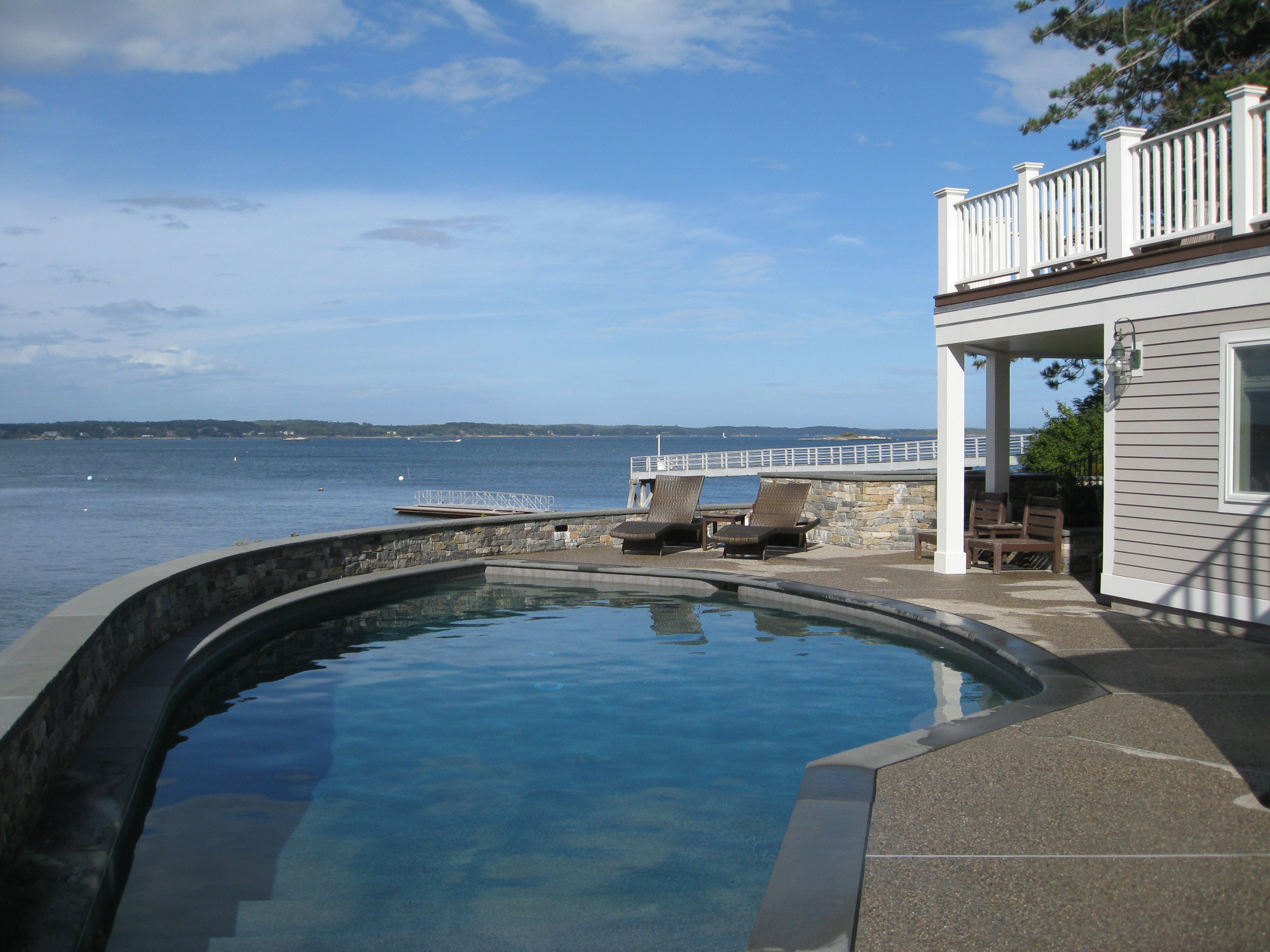The pool and hot tub share the view with the water beyond