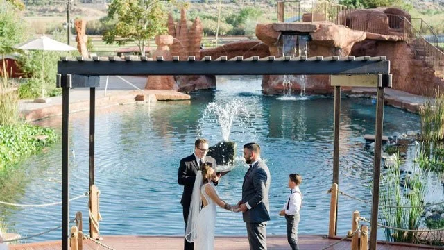 Wedding reception at The Roost event venue in St. George, Utah with waterfall features and outdoor ceremony space. - St George Wedding Invitations