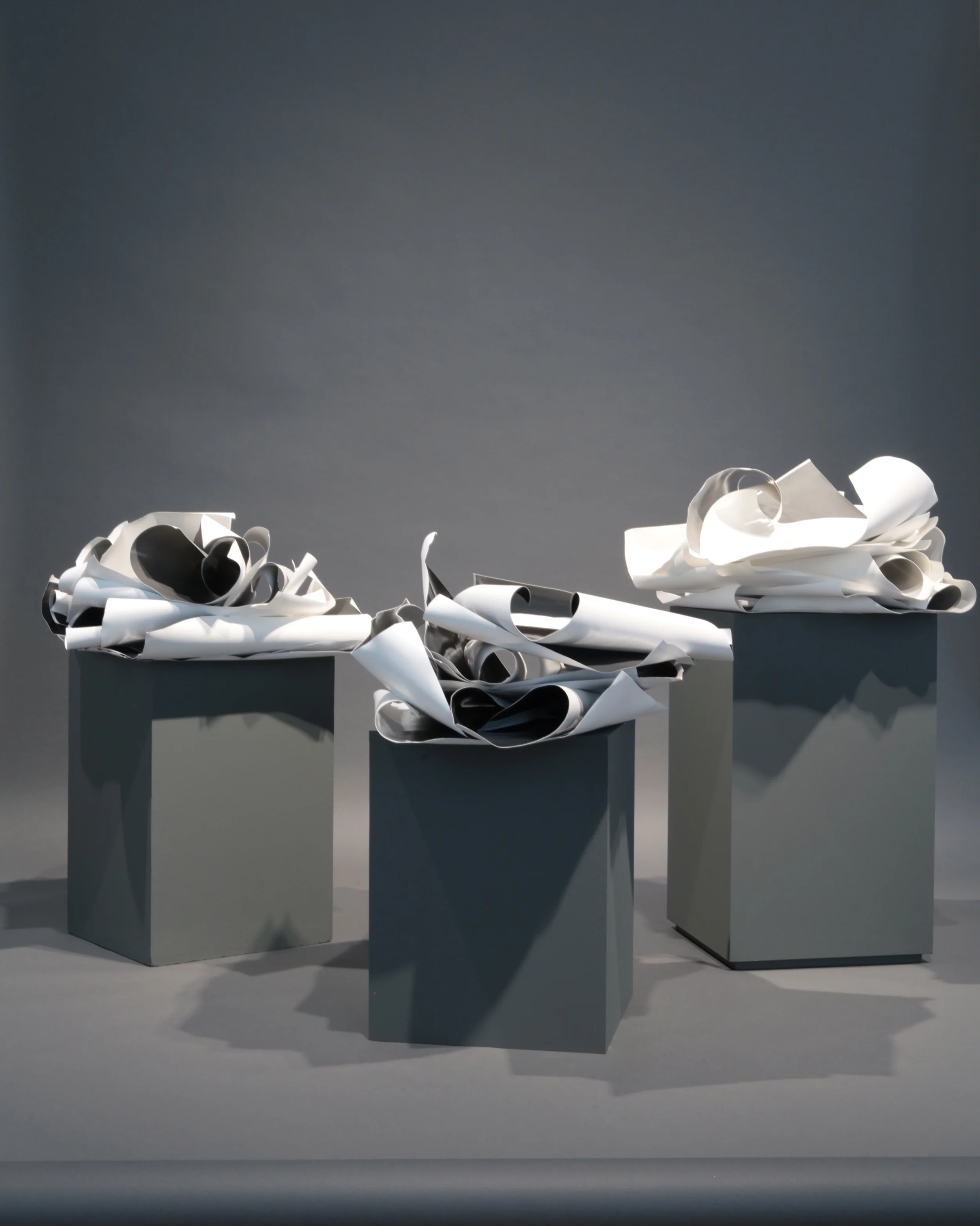 Posed (2015) Three stacks of silver gelatin prints on baryta paper, plinths of wood and neutral grey backdrop Installation, variable dimensions Photo documentation: Adriana Alves/Kunsthall 3,14 Installation view at Past Continuous in a Conditional Present, Kunsthall 3,14, Bergen 2015