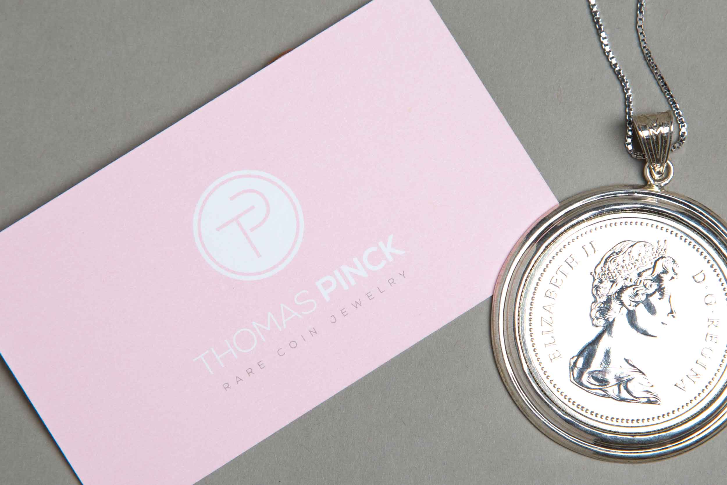 Business card and rare coin necklace for the Thomas Pinck brand.