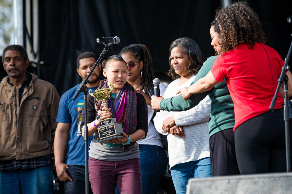 Minna Nilanot, surrounded by Kevin’s family and friends, accepts the inaugural Kevin Kareem Cross Change Makers Award at the 2018 National Cannabis Festival on April 21, 2018