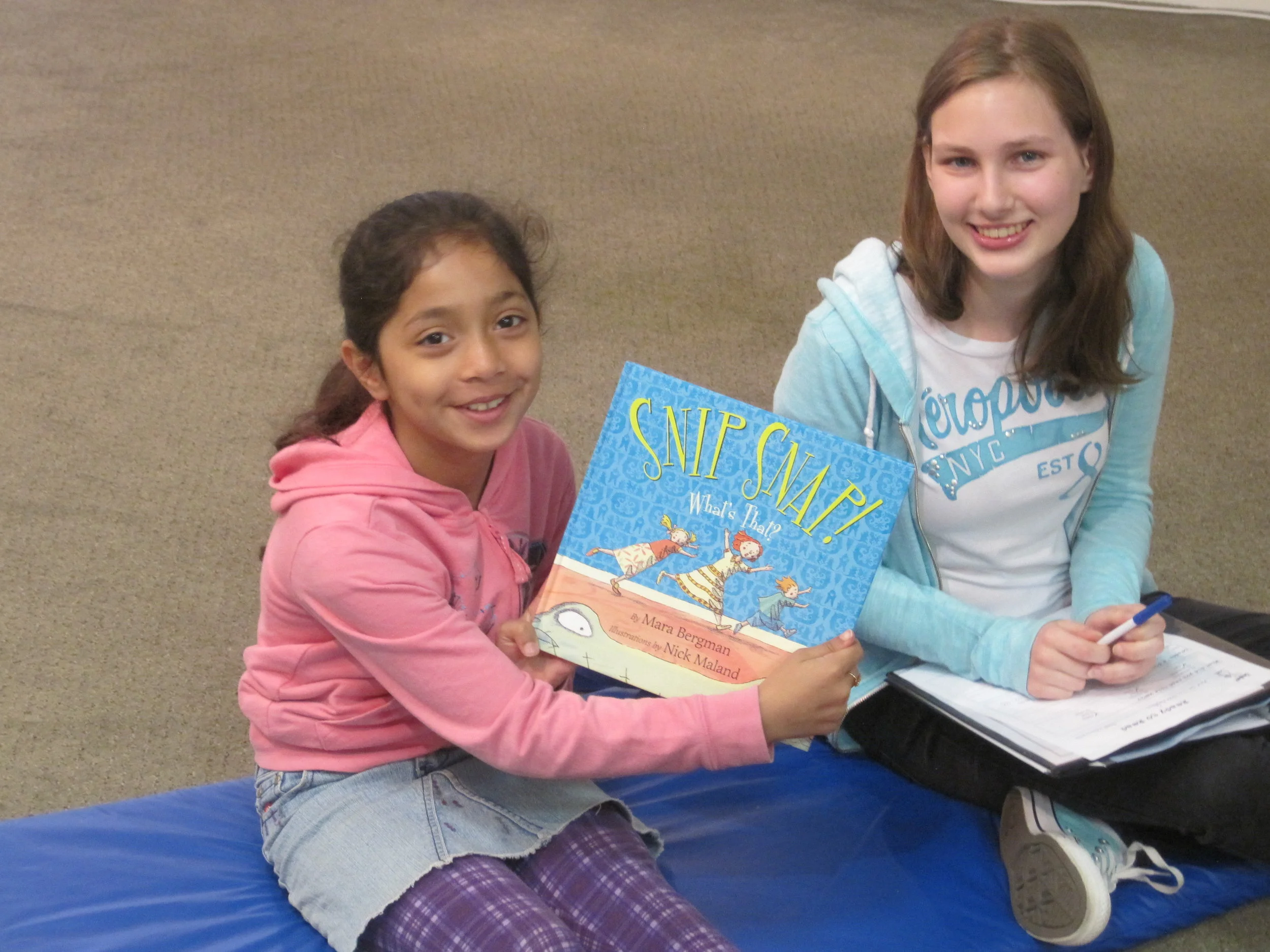 Marwa shows off one of her favourite books to read to her leader, Kate.