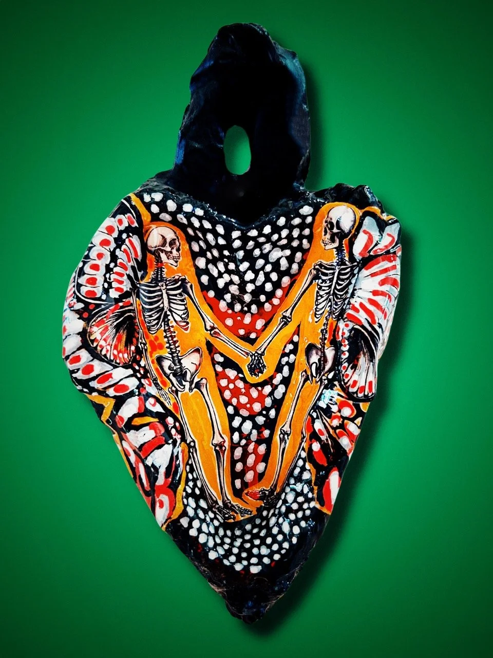 Sculptural heart with painted butterfly wings and skeletons holding hands