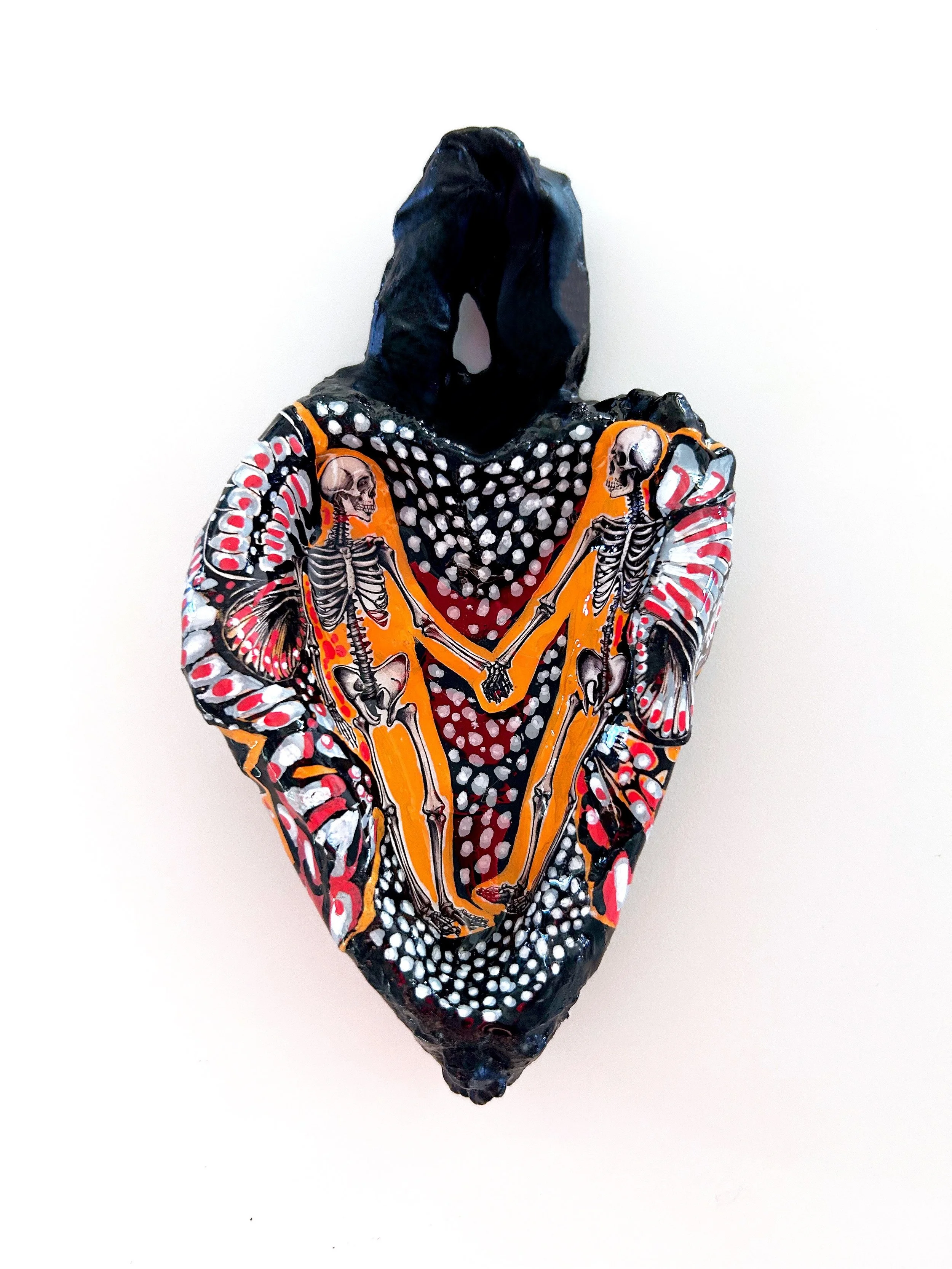 Sculptural heart with painted butterfly wings and skeletons holding hands