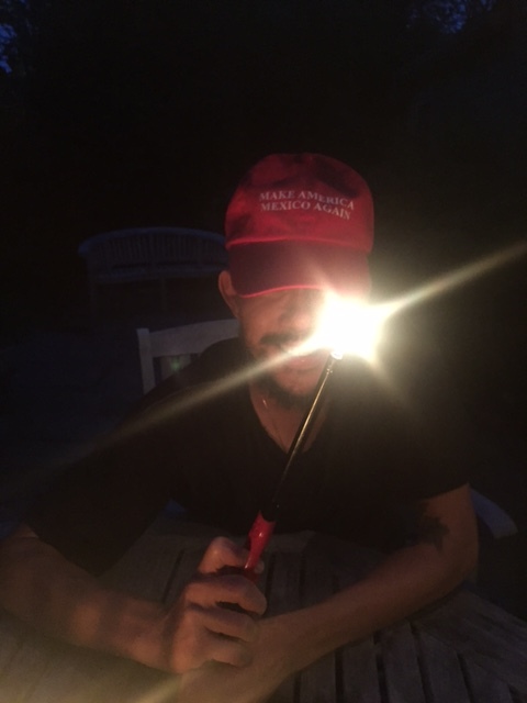 A friend, wearing a baseball cap that pokes fun of Trump's campaign propaganda. 