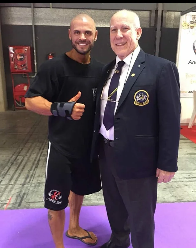 Kie West, who overcame a broken wrist to finish in the top 10 in classic bodybuilding, with UKBFF president Bill Tierney.