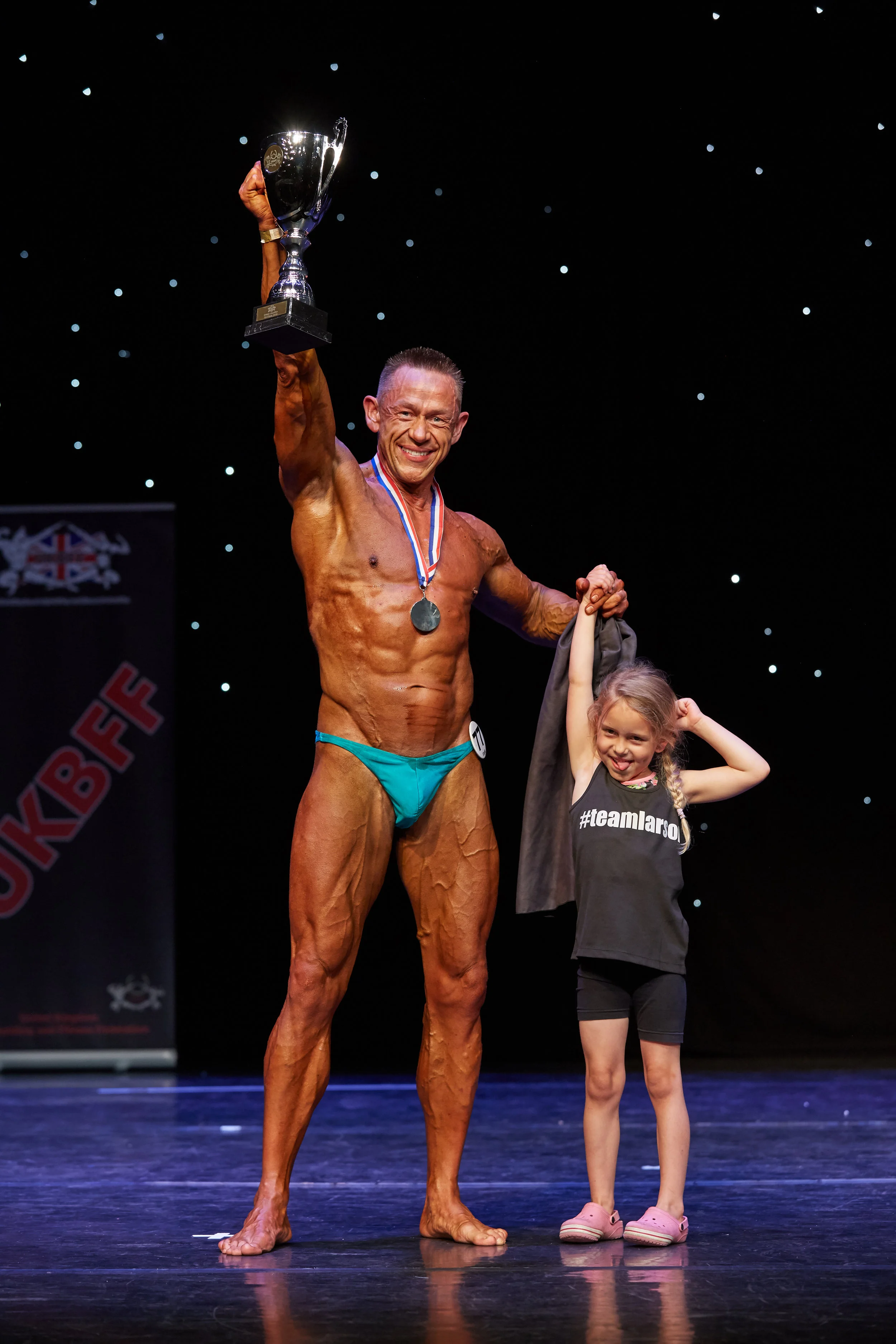 Anthony Larson has a moment to treasure with his daughter after winning classic physique.