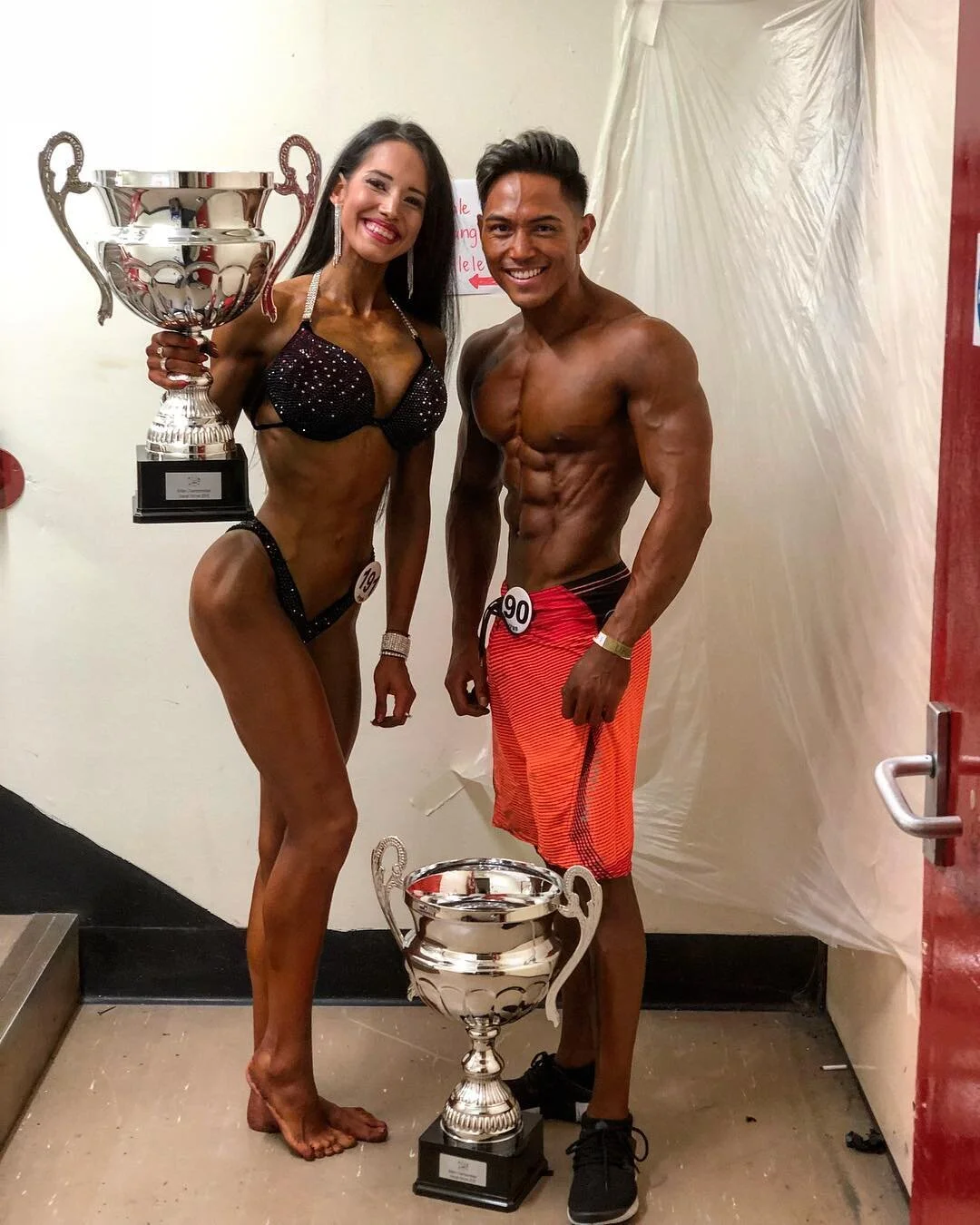 Marta Mila and El Noval, last year’s bikini fitness and men’s physique overall champions, pose backstage with their trophies.