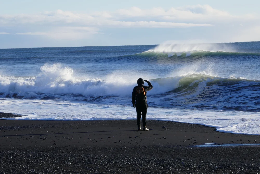  Julien checking out the surf break on a black sand beach 
