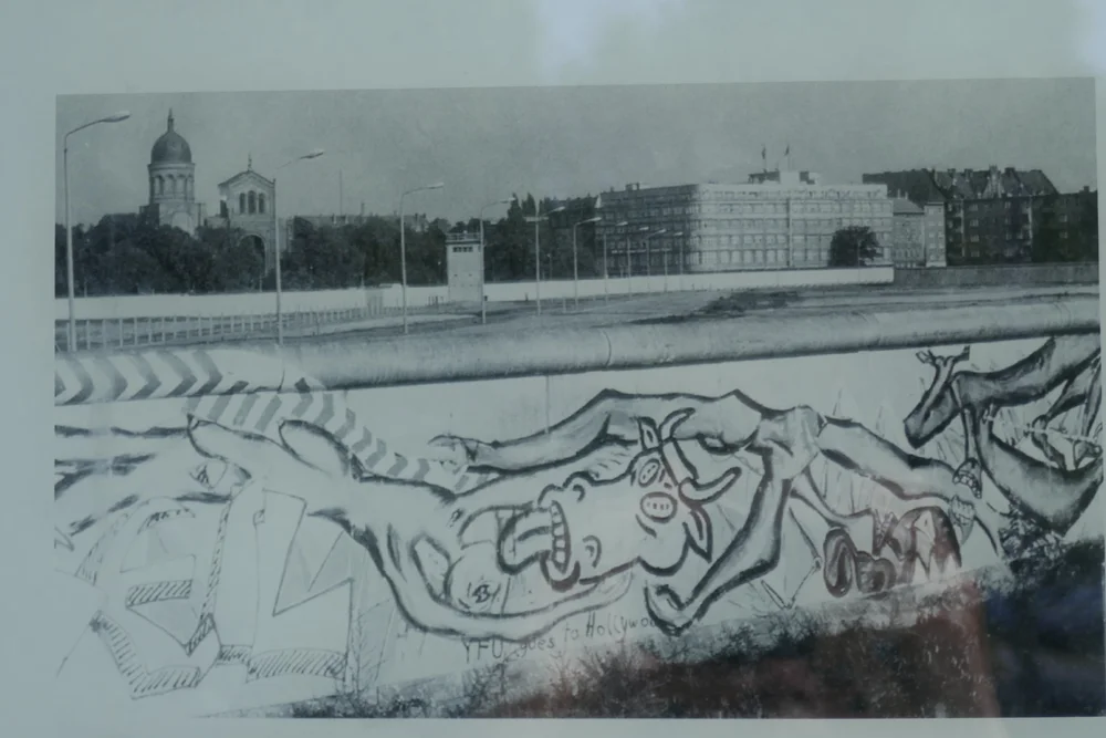 Graffiti on the west side of the wall; behind the death strip, you can see the St. Michael Kirche in the background 