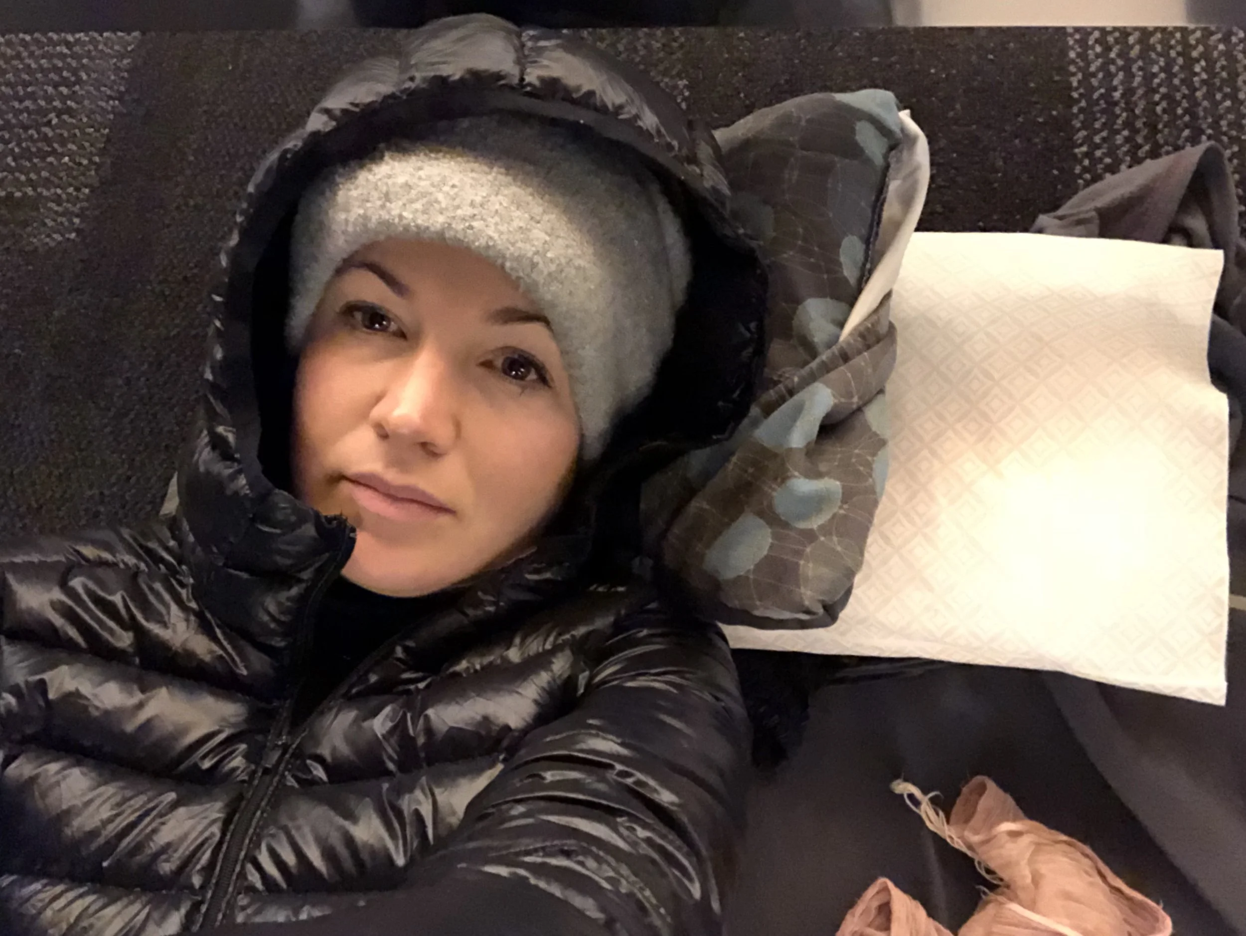 All bundled up and bleary eyed in my very own fort under a couple rows of chairs in the family quiet zone. 