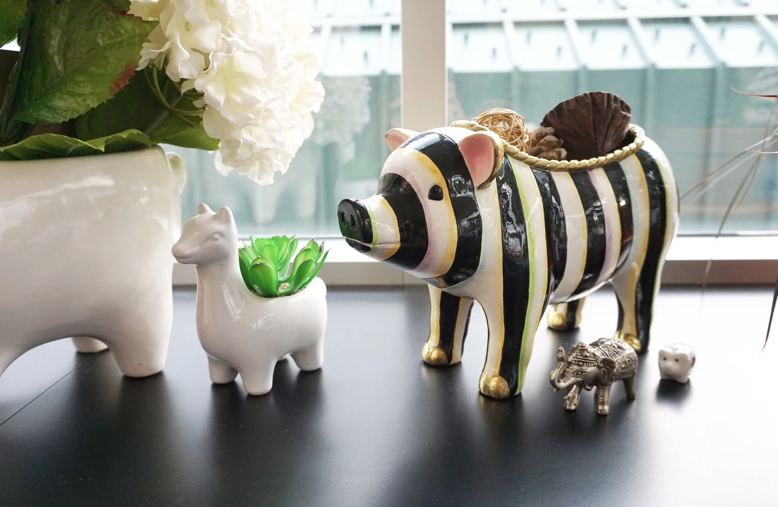 I love decor with animal faces. This piggie is from Mackenzie Childs and the two llamas are from West Elm.