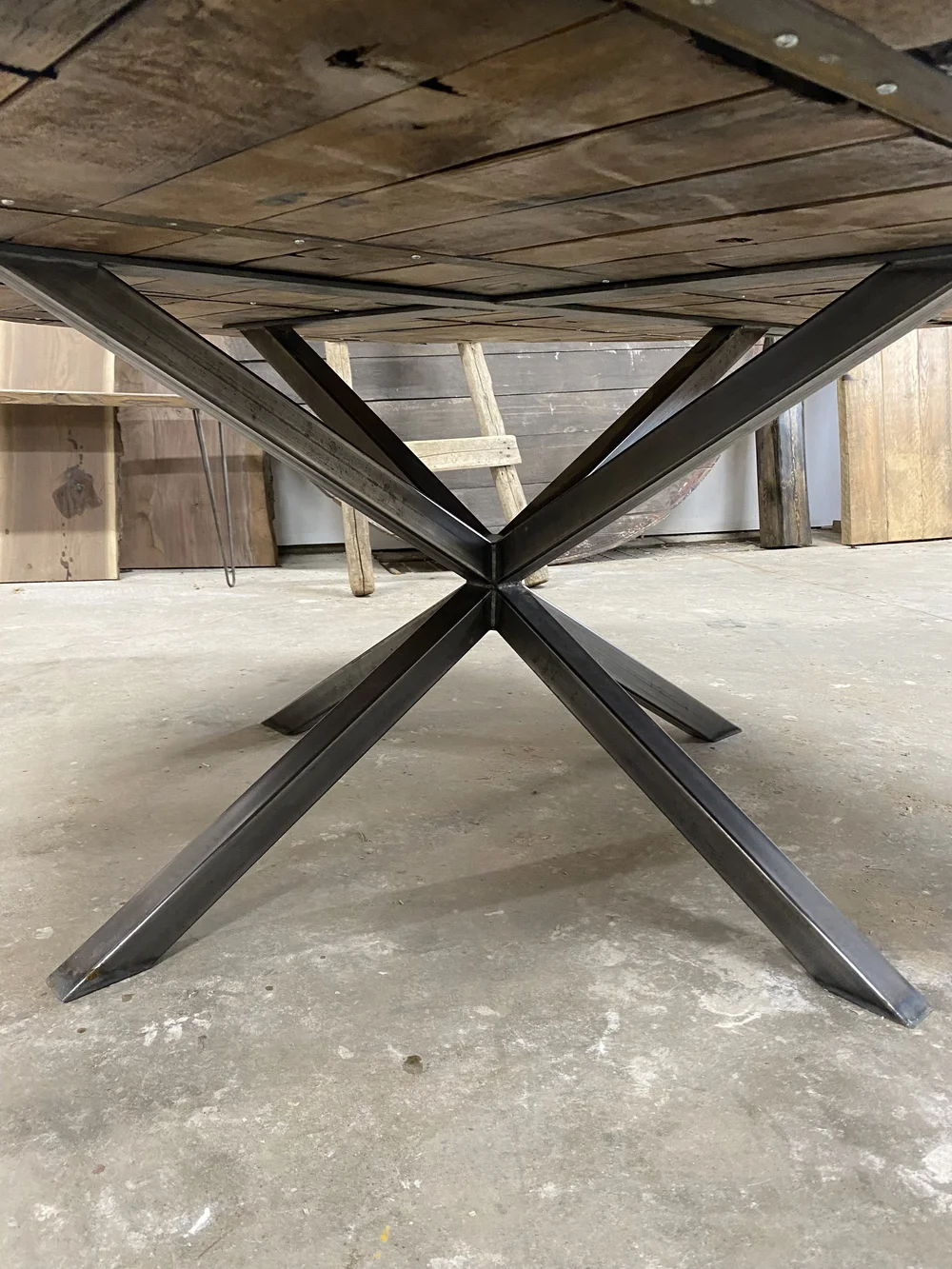 A round table made from a wine barrel lid sits in the shop of collingwood custom furniture maker