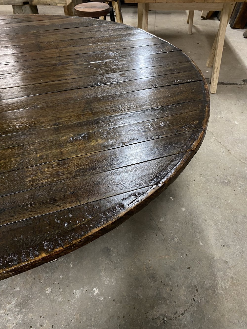 A round table made from a wine barrel lid sits in the shop of Toronto custom furniture maker