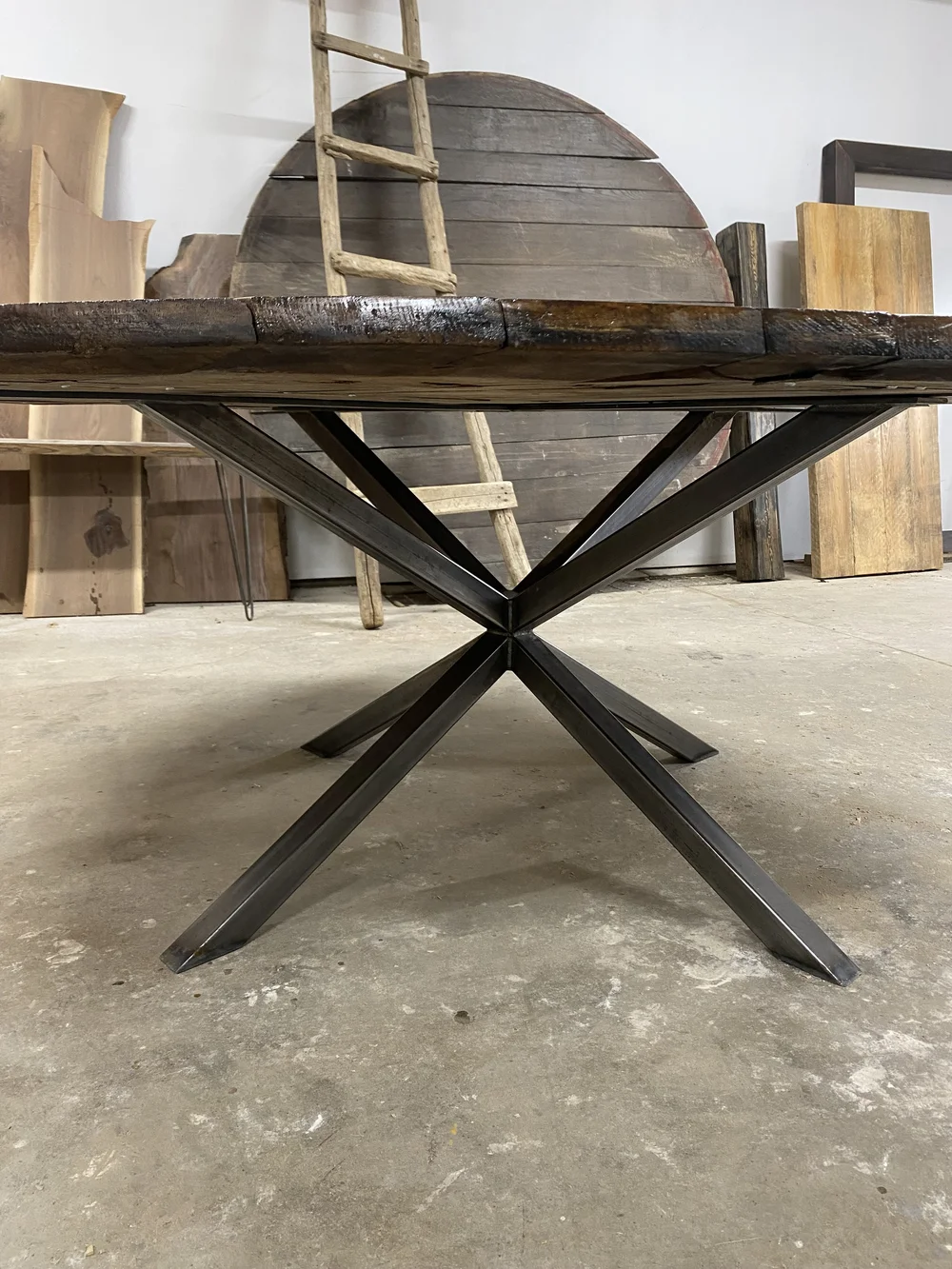A round table made from a wine barrel lid sits in the shop of collingwood custom furniture maker