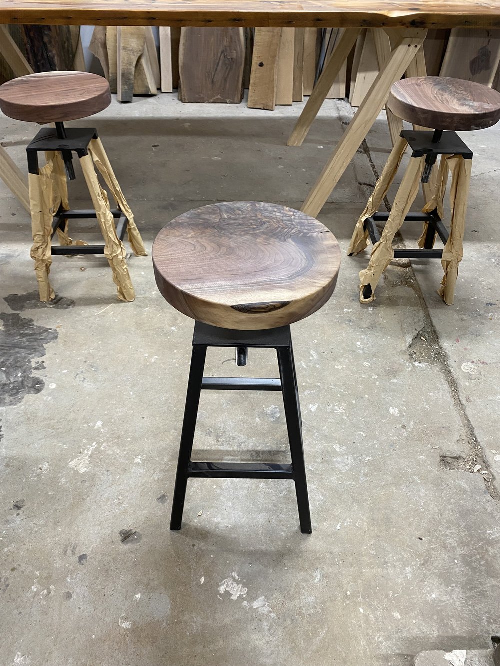 custom made high top stools with black walnut wooden seats and black metal base.