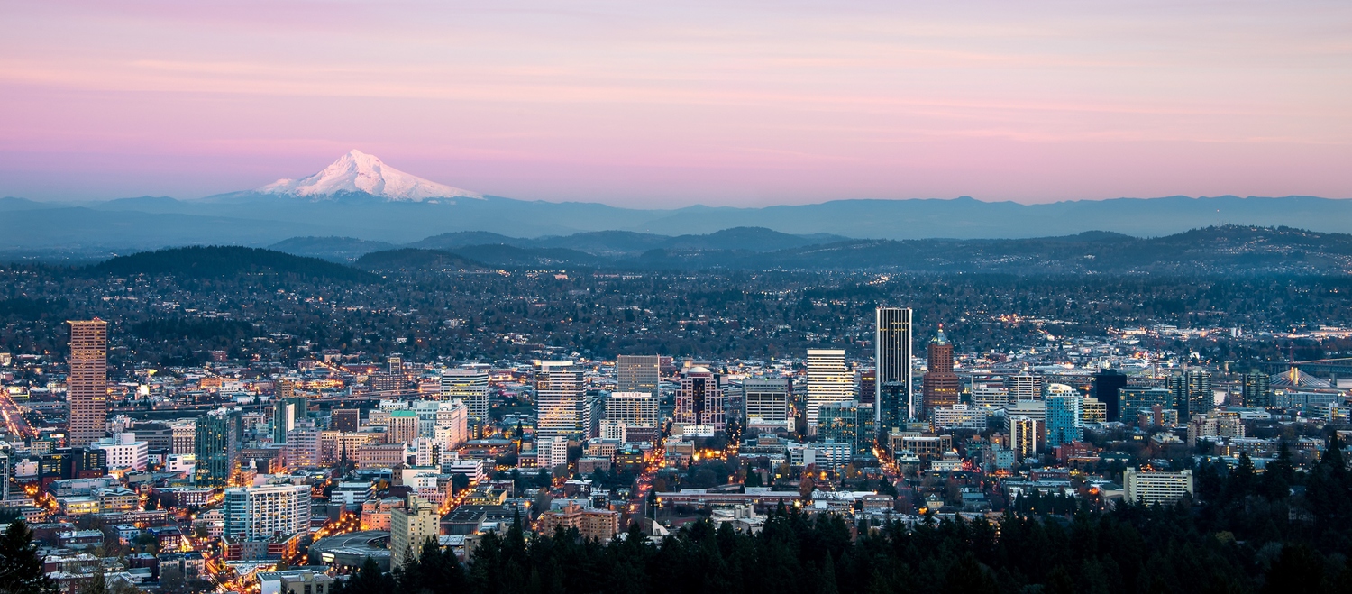 Downtown Portland, Oregon USA on a spring evening looking east towards the 11,250 foot high Mt Hood, 50 miles in the distance. Taken atop the city's tallest locale, the 1,000 foot high Council Crest in the West Hills of Portland.